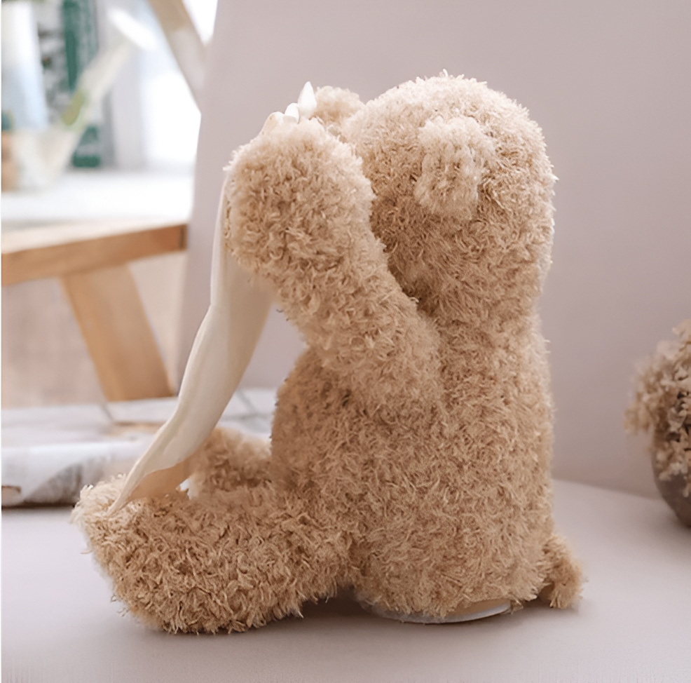 Interaktiver Plüsch-Teddybär in Braun von hinten seitlich mit hellen Tuch