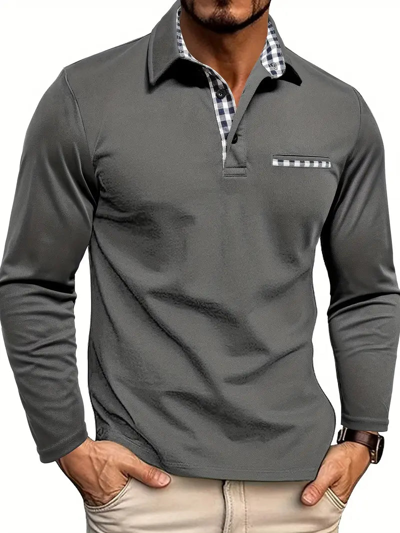 Mann trägt das Langarm-Poloshirt in Grau mit karierter Knopfleiste, Krageninnenseite und Brusttasche, Hände in den 1