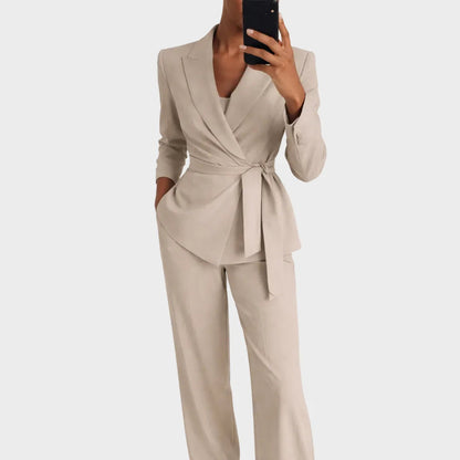 Dasselbe Set in Beige: Wickelblazer mit Bindegürtel und weiter Hose, getragen von einer Frau mit Handy in der Hand.