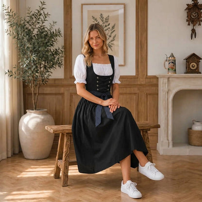 Frau im schwarzen Midi-Dirndl seitlich auf einer Holzbank, Detail