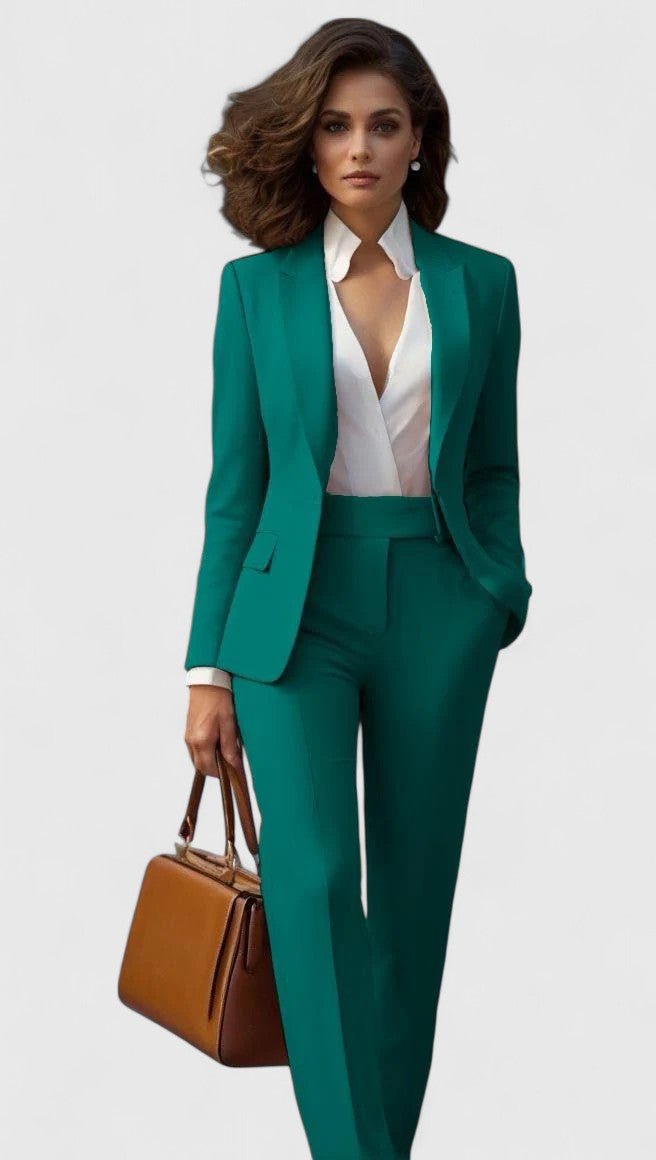Das Set in Smaragdgrün, einreihiger Blazer mit Spitzrevers und gerade geschnittene Hose, kombiniert mit weißer Bluse und brauner Tasche. 4