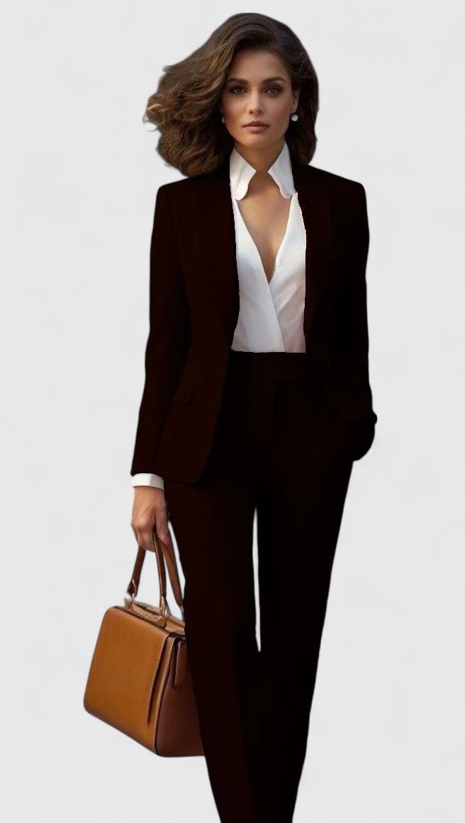 Schwarzes Set aus langärmeligem Blazer und weit geschnittener Hose, dazu weiße Bluse mit tiefem Ausschnitt und braune Tasche. 7
