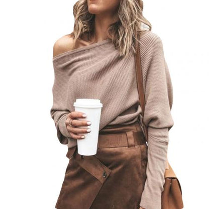 Frau in beigem Off-Shoulder-Pullover, braunem Rock, hält Kaffeebecher, modisch, lässig.