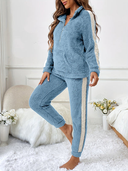 Frau in blauem Fleece-Trainingsanzug mit weißen Streifen, gemütlich, modisch, Wohnzimmer.