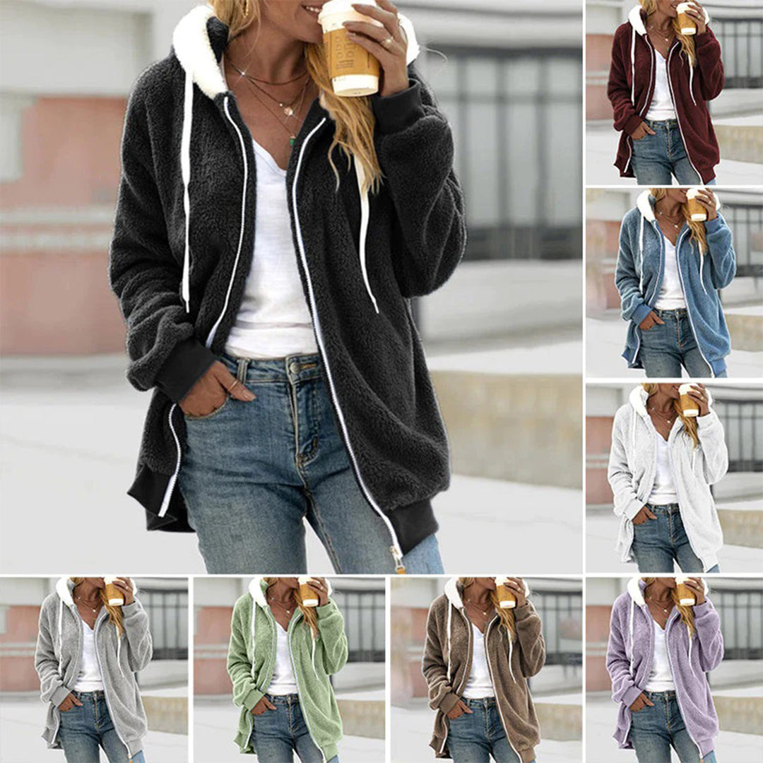 Frau in schwarzer Fleecejacke mit Kapuze, hält Kaffee, lässige Mode, verschiedene Farben.