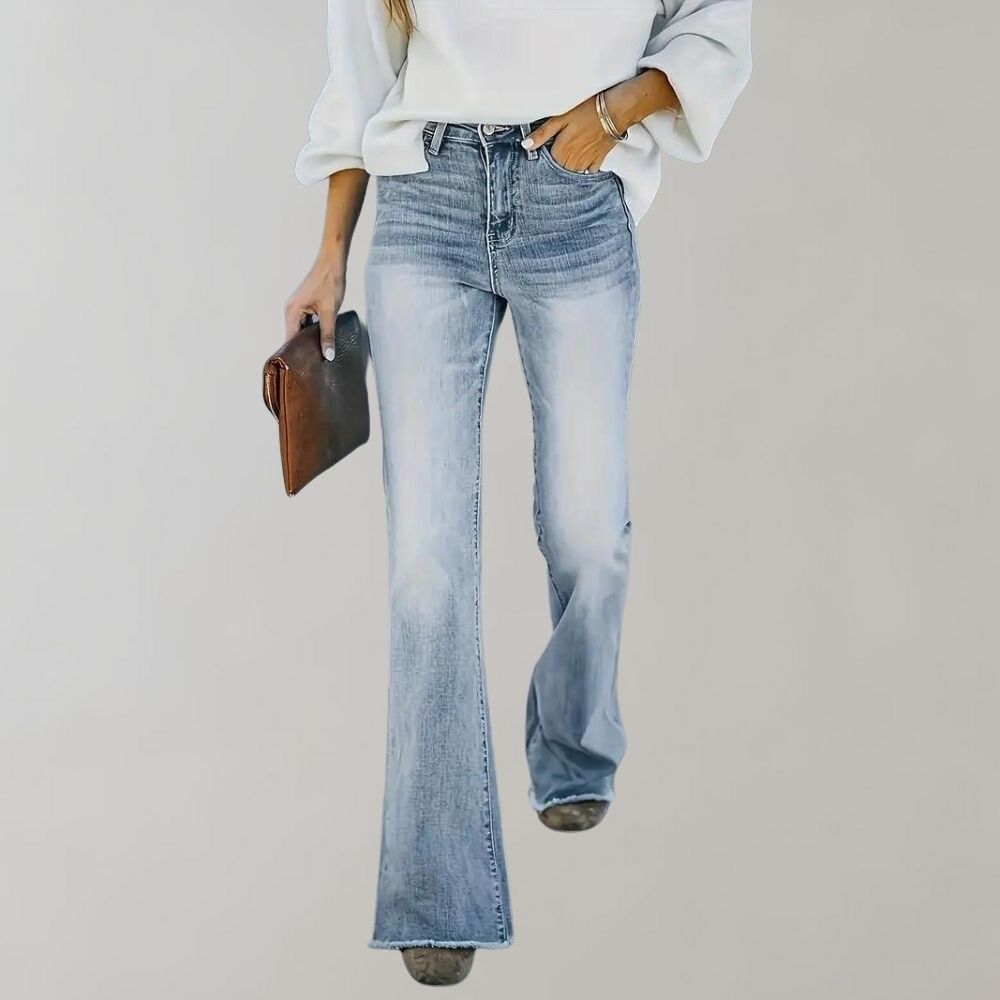 Frau in blauer Schlagjeans und weißem Pullover, hält braune Clutch, modisch, lässiger Stil.