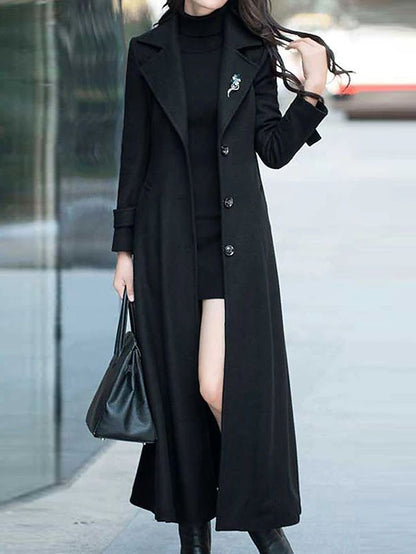 Frau in schwarzem Wollmantel, trägt schwarze Tasche, eleganter Herbst-Look, Stadtstraße.