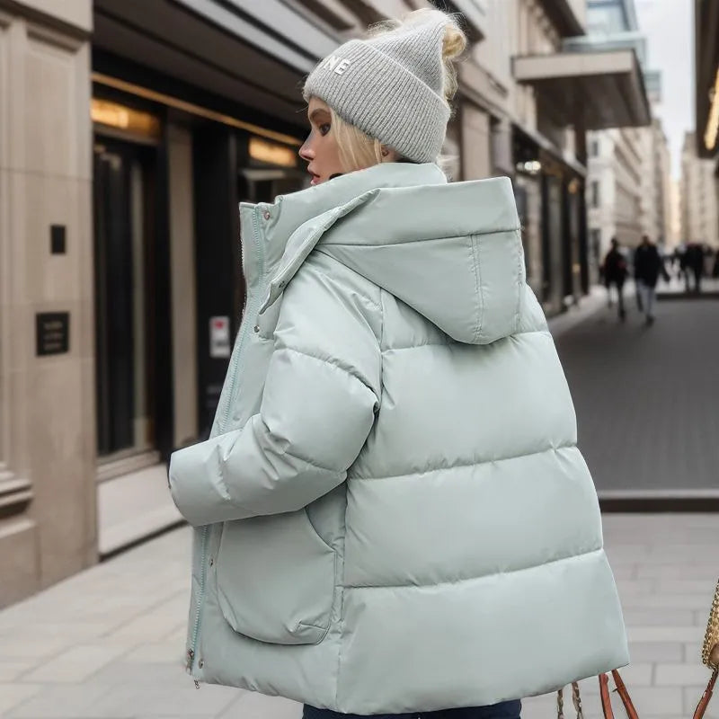 Frau in hellblauer Daunenjacke mit Kapuze, Wintermode, warm, winddicht, Stadtstraße.