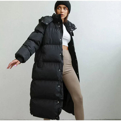 Frau in schwarzem Daunenmantel, Wintermode, lange Jacke, warm, stilvoll, modern, Outdoor-Bekleidung.