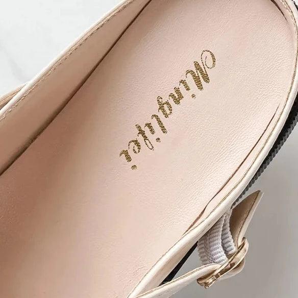 Beige Damenleder-Mules, stilvoll und bequem, mit goldener Aufschrift, ideal für Freizeit.