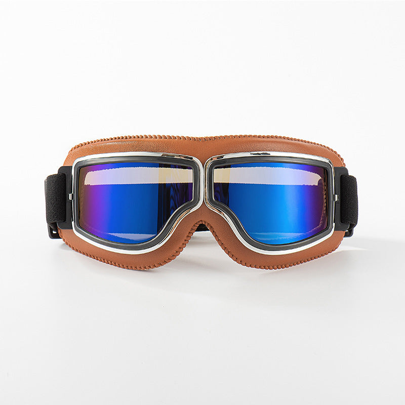 Brille mit hellbraunem Lederrand und Chromrahmen, die Gläser schimmern verspiegelt in Blau, auf weißem Hintergrund. 9