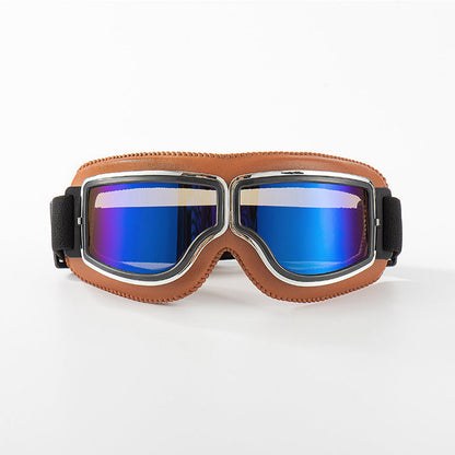 Brille mit hellbraunem Lederrand und Chromrahmen, die Gläser schimmern verspiegelt in Blau, auf weißem Hintergrund. 9