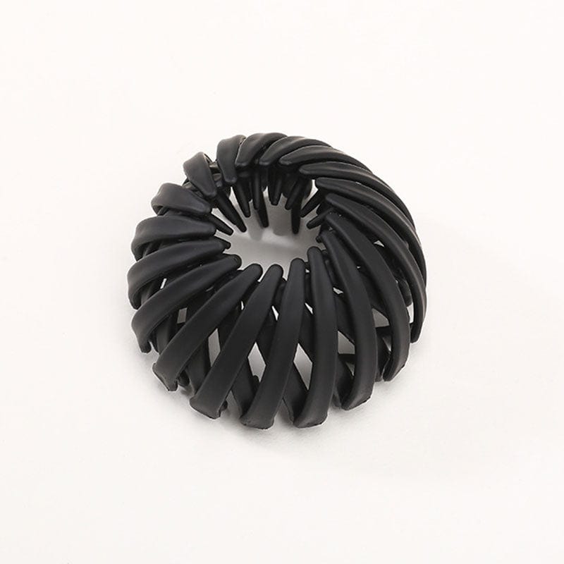 Matte Haarklammer in Schwarz mit spiralförmig angeordneten Rippen, einzeln vor hellem Hintergrund.