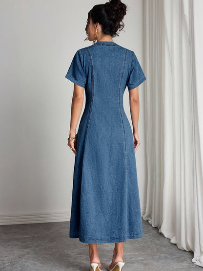 Rückansicht des Jeanskleids mit kurzen Ärmeln, Teilungsnähten und ausgestelltem Rock, getragen von einem Model 2