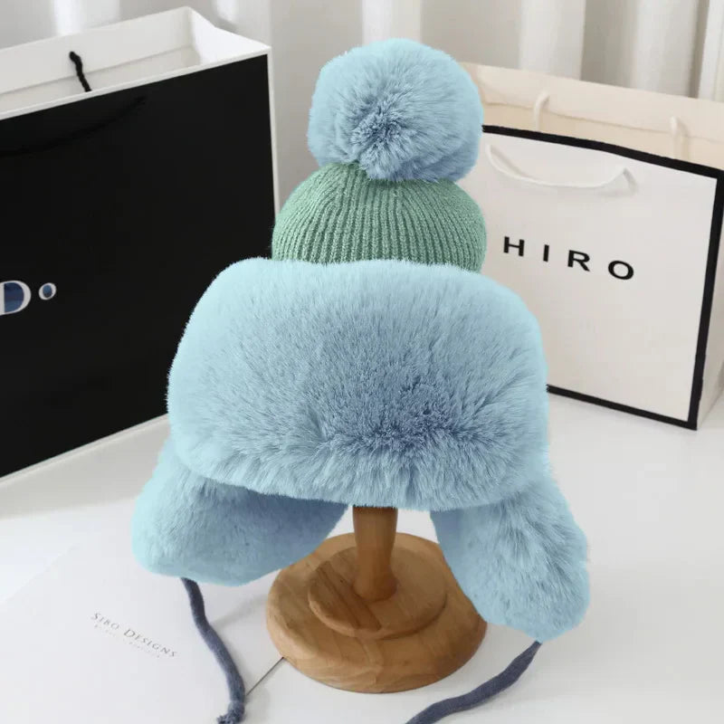 Blaue Plüschmütze mit Bommel, Winteraccessoire, warm, stilvoll, für kalte Tage.