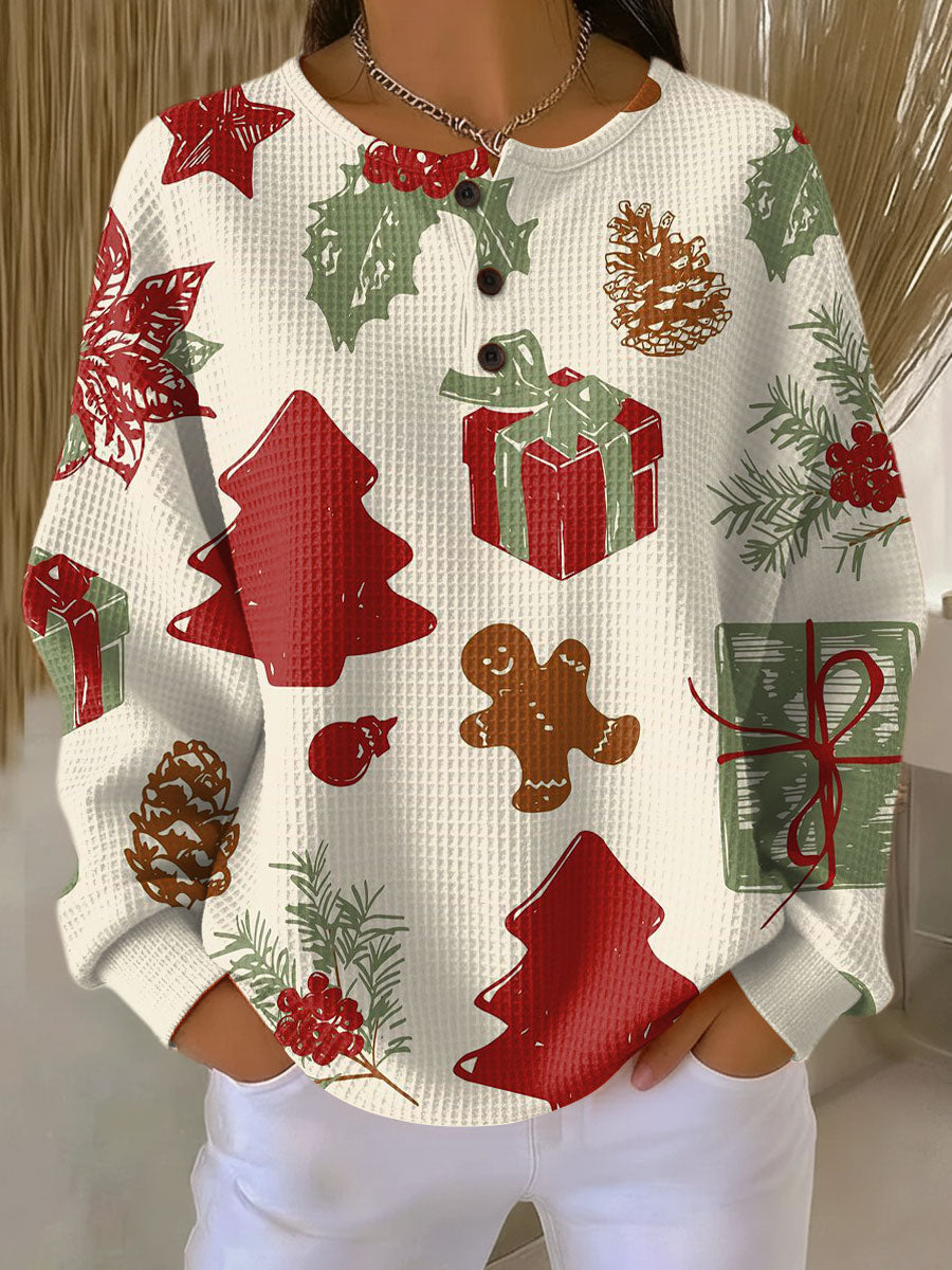 Cremefarbene Waffelstrick-Variante mit Knopfleiste, getragen zur weißen Hose, buntes Muster mit Lebkuchenmännchen, Geschenken, Tannenzapfen, Stechpalmenblättern 23
