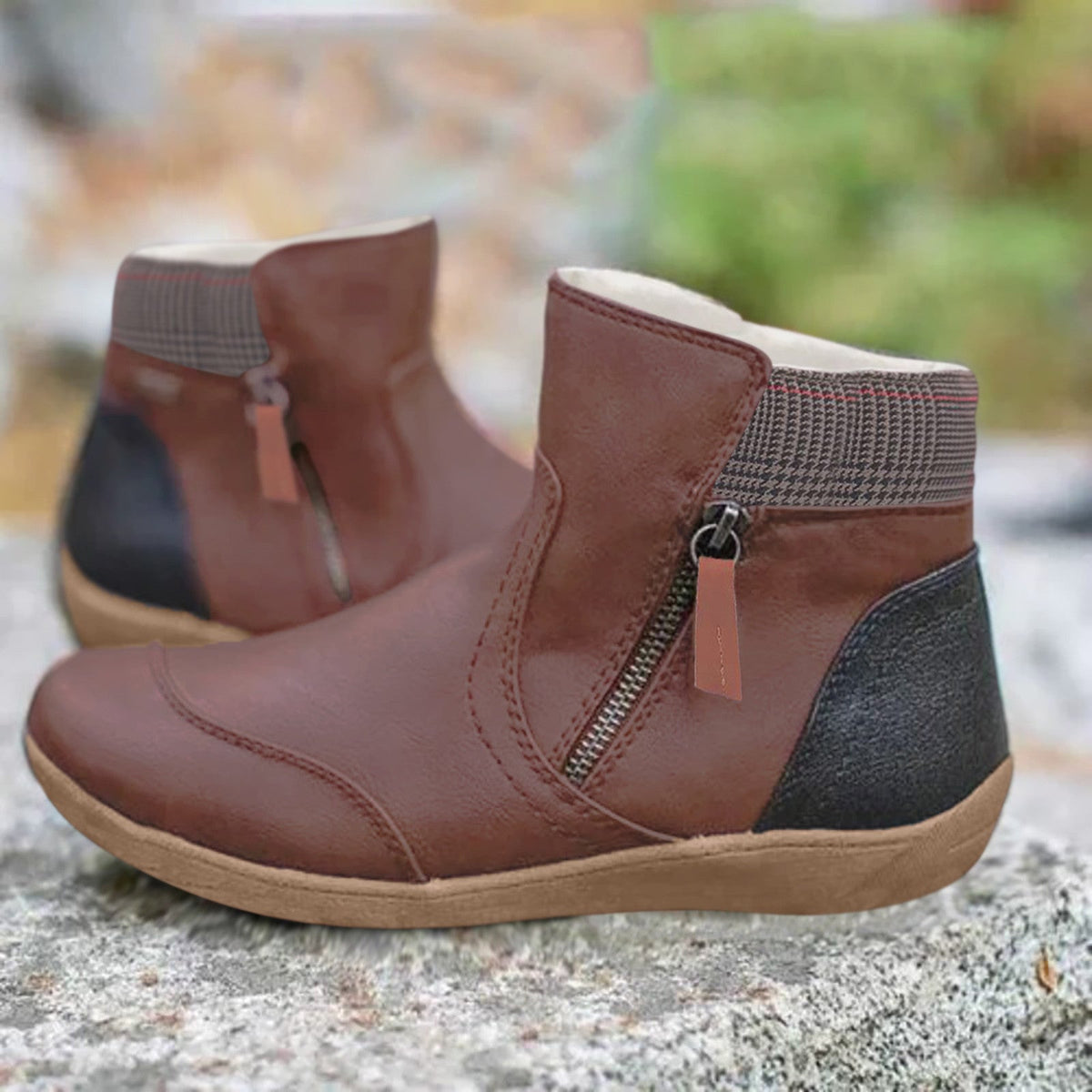 Braune Stiefeletten mit Reißverschluss an der Seite, karierter Manschette und schwarzer Fersenpartie, Detail.