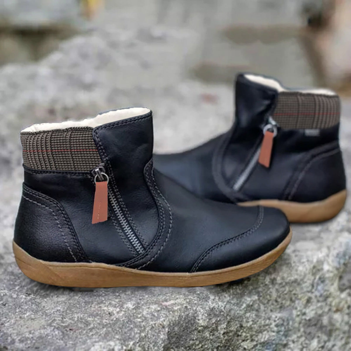 Schwarze Stiefeletten mit seitlichem Reißverschluss, orangebrauner Zuglasche und kariertem Schaftrand, Detail.
