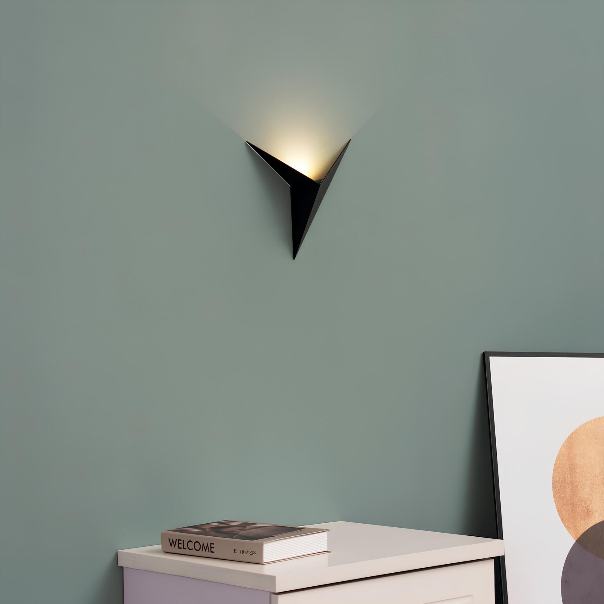 Moderne schwarze Wandleuchte, dreieckig, minimalistisch, auf grüner Wand, Innenbeleuchtung.