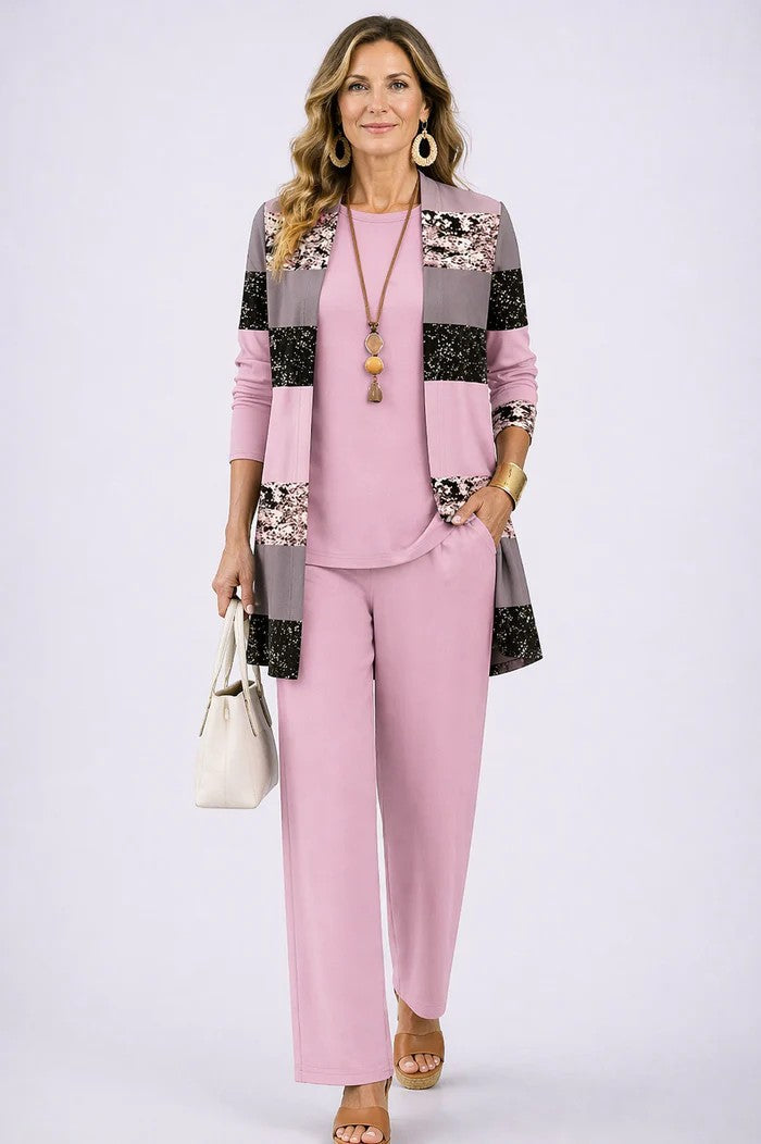 Frau im rosa Set, Cardigan mit breiten Streifen in Rosa, Grau und Pailletten-Optik, dazu rosa Shirt und weite Hose. 12