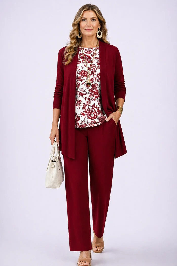 Frau im weinroten Set mit einfarbigem Cardigan und Hose, dazu weißes Shirt mit rotem Blumenmuster. 13