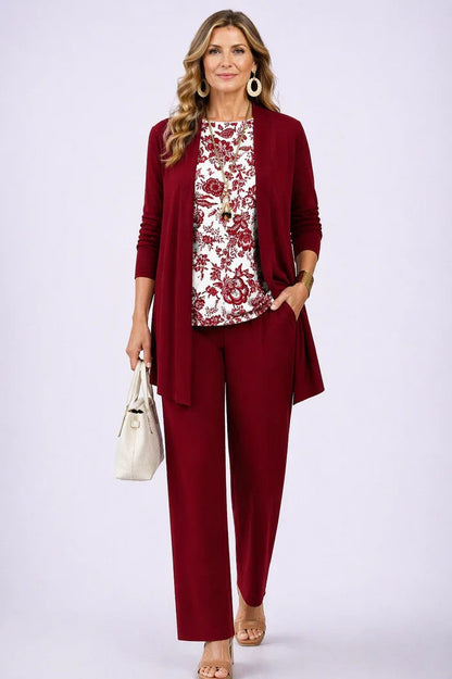 Frau im weinroten Set mit einfarbigem Cardigan und Hose, dazu weißes Shirt mit rotem Blumenmuster. 13