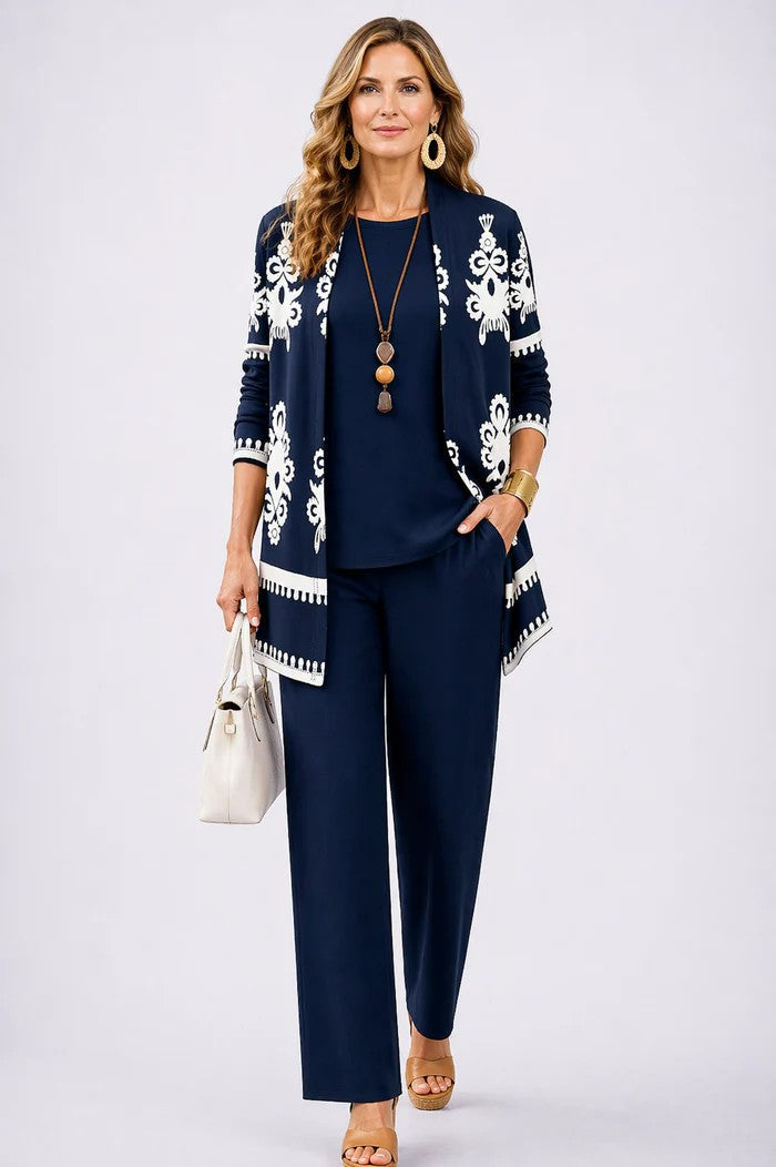 Frau im marineblauen Set, Cardigan mit weißem Ornamentmuster und Bordüren, dazu marineblaues Shirt und weite Hose. 14