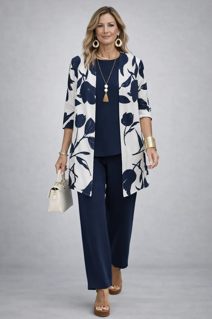 Frau im Set mit weißem Cardigan mit marineblauem Tulpenmuster, dazu marineblaues Shirt und weite marineblaue Hose. 15
