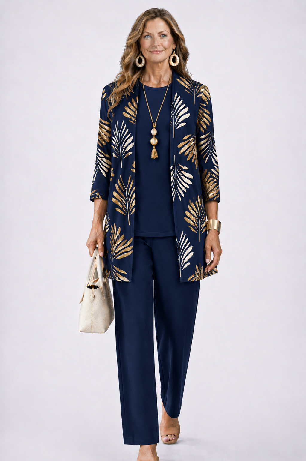Frau im marineblauen Set mit goldenem Palmblattmuster auf dem offenen Cardigan, dazu Shirt und weite Hose in Marineblau. 7