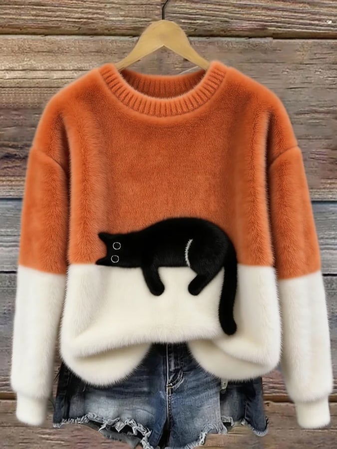 Orange-weißer Flauschpullover mit schwarzer Katze auf Kleiderbügel vor Holzwand, darunter Jeansshorts 4