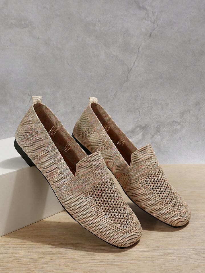Beige Slip-on-Sneaker mit Fersenlasche, an einen weißen Block gelehnt