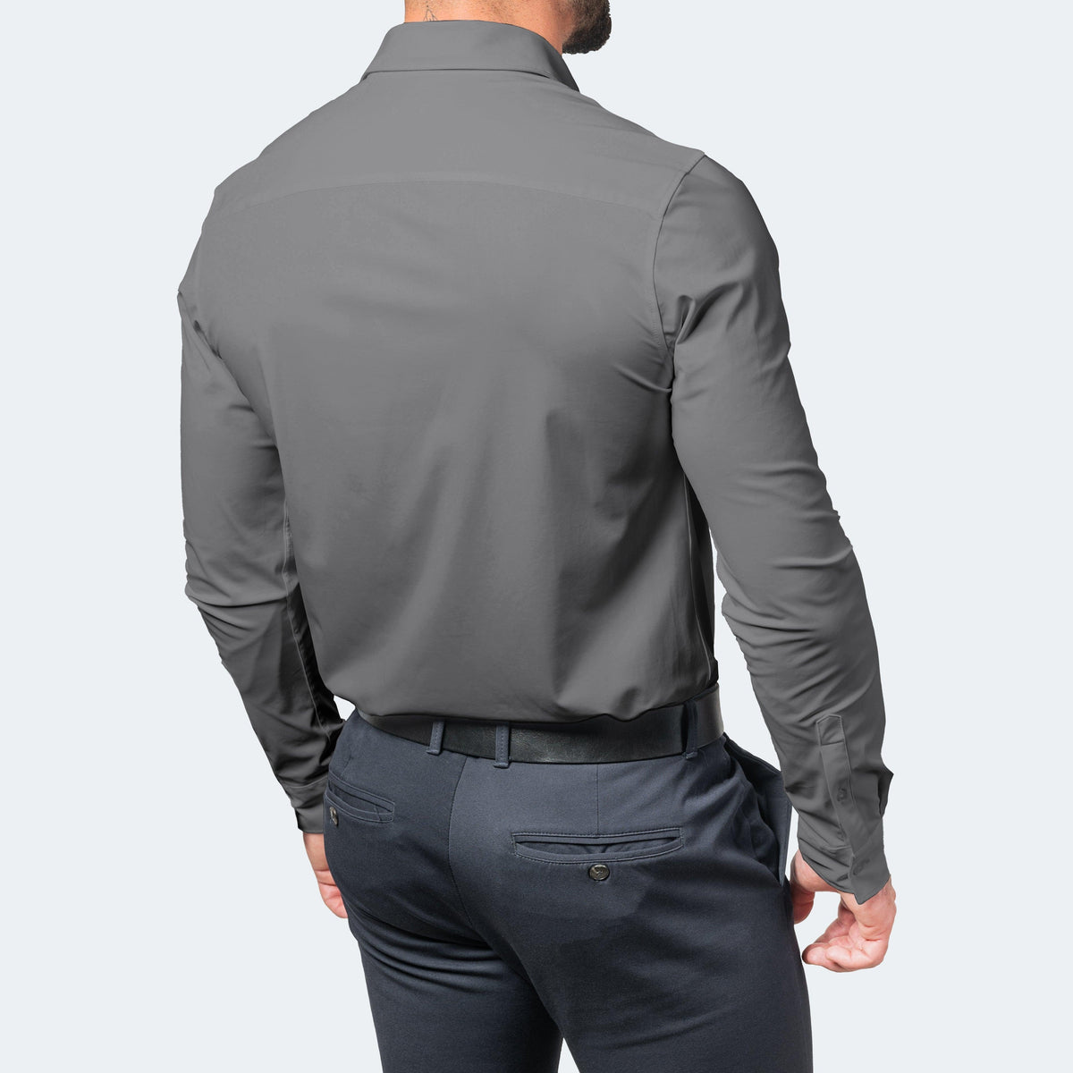 Rückansicht eines grauen Herrenhemds mit dunkelblauer Hose und schwarzem Gürtel.
