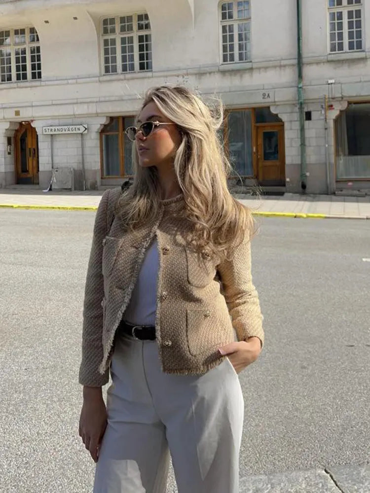Frau in Kamel-Tweed-Jacke, Herbstmode, lange Ärmel, O-Ausschnitt, modisch, urbaner Hintergrund.