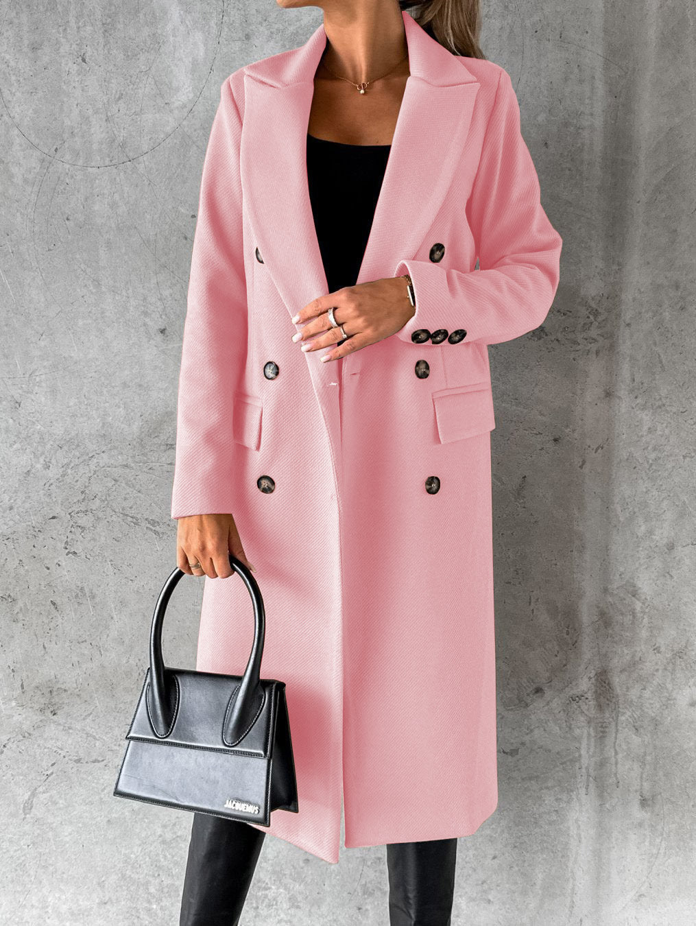 Eleganter rosa Damenmantel, doppelt geknöpft, mit schwarzer Handtasche, stilvoll und modern.