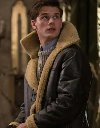 Junger Mann blickt nach oben, getragen die dunkle Lederjacke mit hochgestelltem Fellkragen über grauem Strickpullover 5