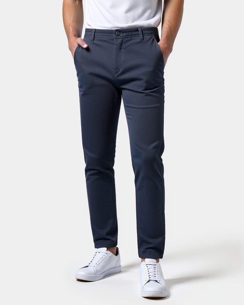 Marineblaue Chino in der Frontansicht mit weißem Shirt und weißen Sneakern.