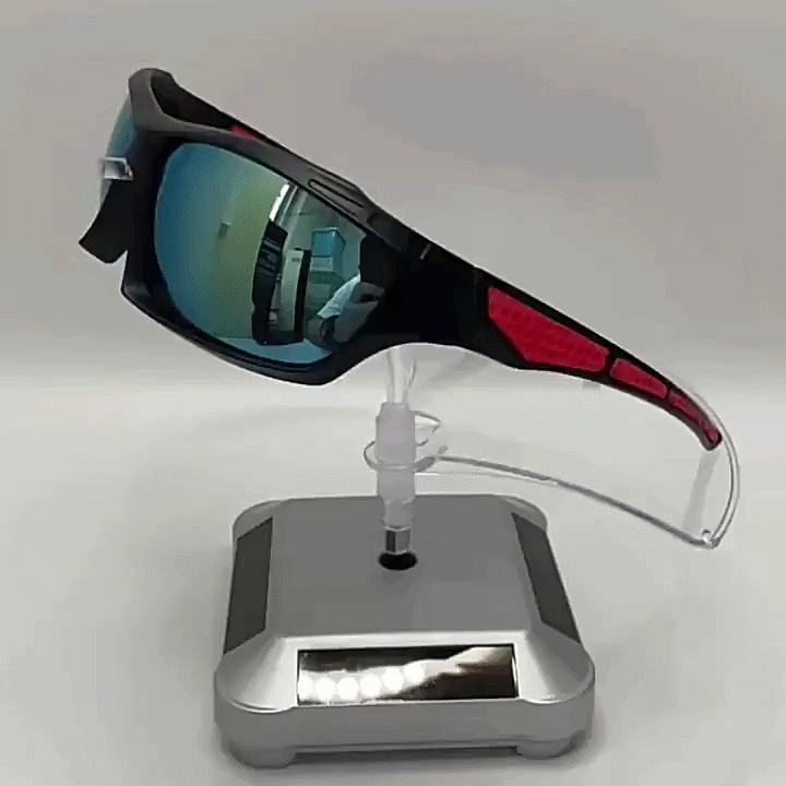 Sportbrille mit verspiegelten Gläsern und roten Bügelakzenten auf einem transparenten Ständer mit silberner Drehplatte 4