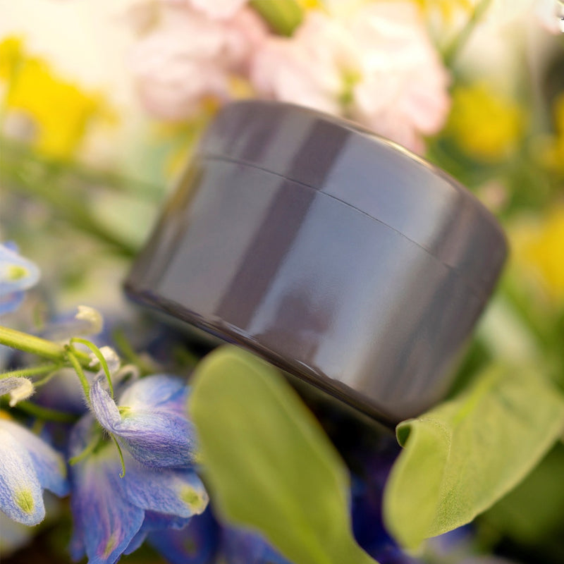 Grauer glänzender Blumenstecker-Vaseneinsatz zwischen Blüten