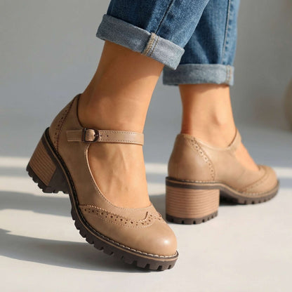 Beige Mary Janes in Seitenansicht mit Schnalle am Knöchelriemen und Holzoptik-Absatz, getragen zu umgeschlagenen Jeans. 3