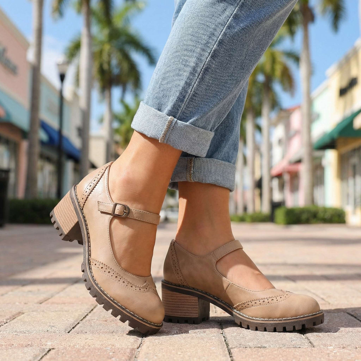 Beige Mary Janes mit Lochmuster und Absatz, zu umgeschlagenen Jeans auf einer Einkaufsstraße unter Palmen getragen. 6