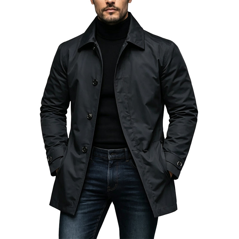 Mann trägt den knielangen Mantel in Schwarz offen über Rollkragenpullover und dunkler Jeans, Hände in den Taschen 1