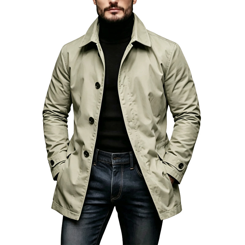 Mann trägt den Mantel in hellem Beige-Grün mit Schulterriegeln und Ärmelriegeln, kombiniert mit Rollkragenpullover und Jeans 3