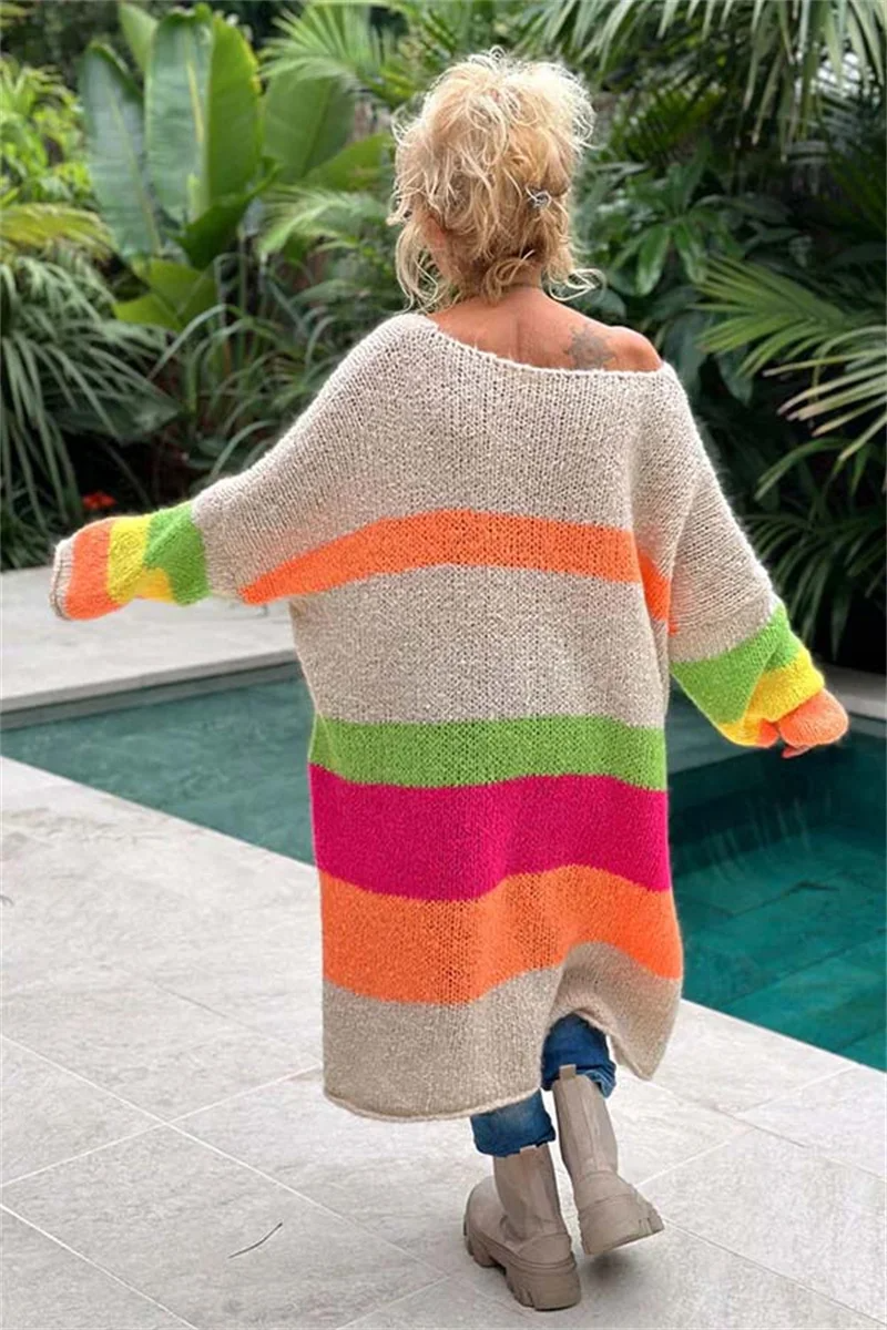 Frau trägt gestrickten Regenbogen-Cardigan, beige mit bunten Streifen, am Pool.
