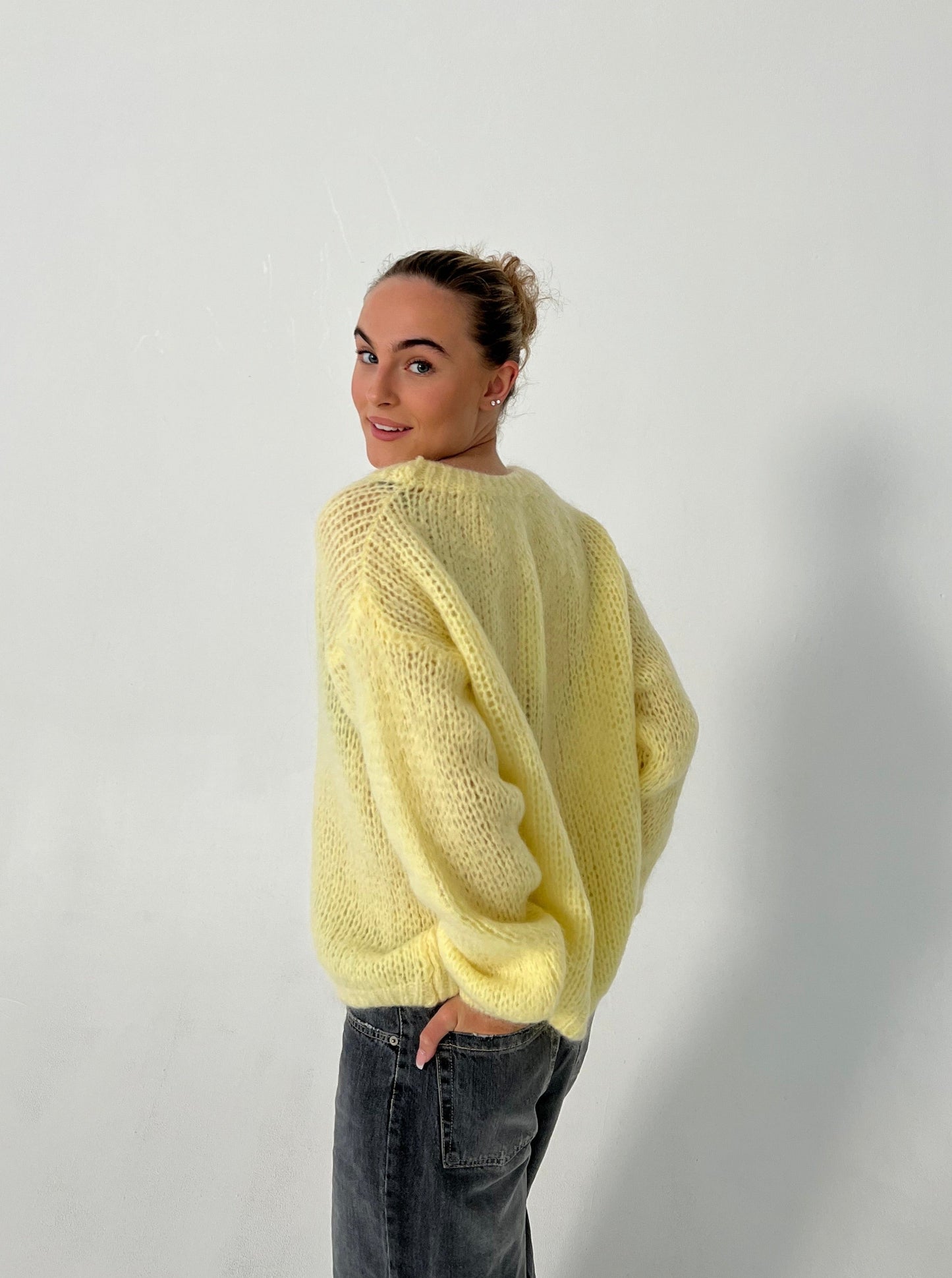 Frau in gelbem Strickpullover, lässig, modisch, Herbstmode, Damenbekleidung, Rückansicht.