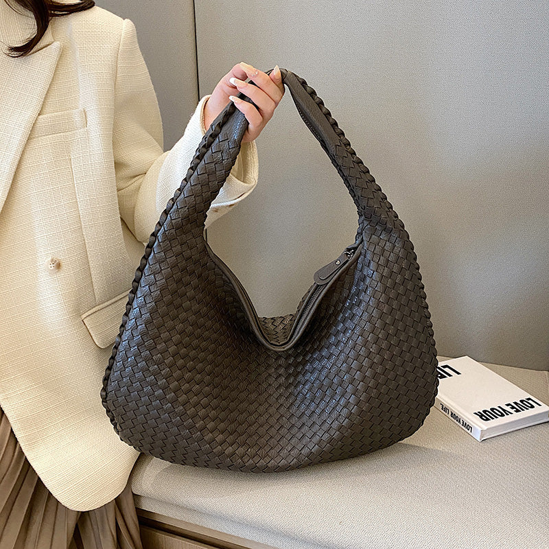 Dunkelgraue geflochtene Handtasche aus Leder, modisch, elegant, Damenaccessoire.