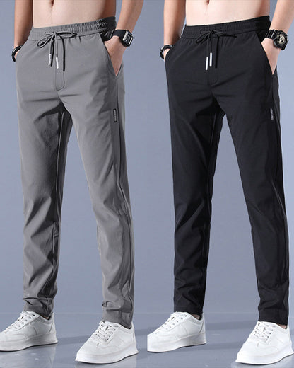 Graue und schwarze Herren-Sporthosen, elastischer Bund, Kordelzug, seitliche Taschen.