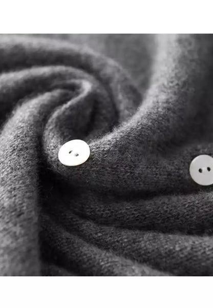 Grauer Wollpullover mit weißen Knöpfen, weiches Material, modisches Design, Herbstmode.