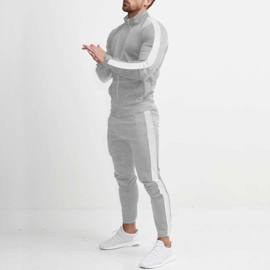 Mann in grauem Trainingsanzug mit weißen Streifen, sportlich, modern, Freizeitkleidung.