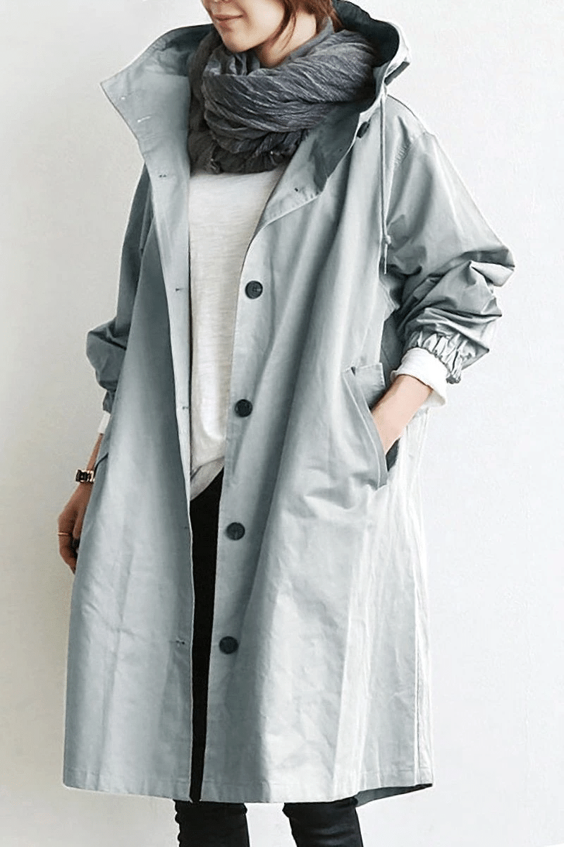 Frau in grauem Trenchcoat mit Schal, modisch, Herbstmode, Damenbekleidung, lässiger Stil.