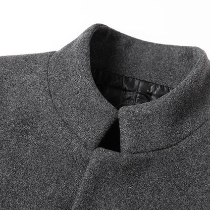 Grauer Wollmantel mit Stehkragen, elegantes Design, warme Wintermode für Herren.
